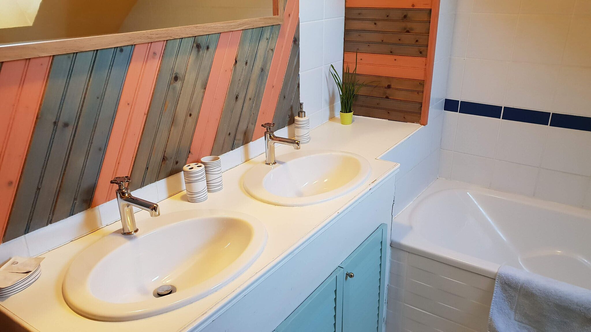 A bathroom with two sinks, a mirror, and a bathtub.