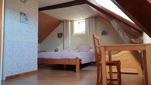 A bedroom with a wooden bed, a chair, and a window with curtains. - La P'tit' Fugue (La Bouexiere)