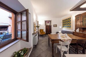 Un espace repas comprenant une table, des chaises, un radiateur, une fenêtre et une vue sur l’extérieur.