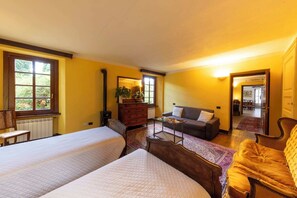 Une chambre avec deux lits, un canapé, une commode et un miroir.