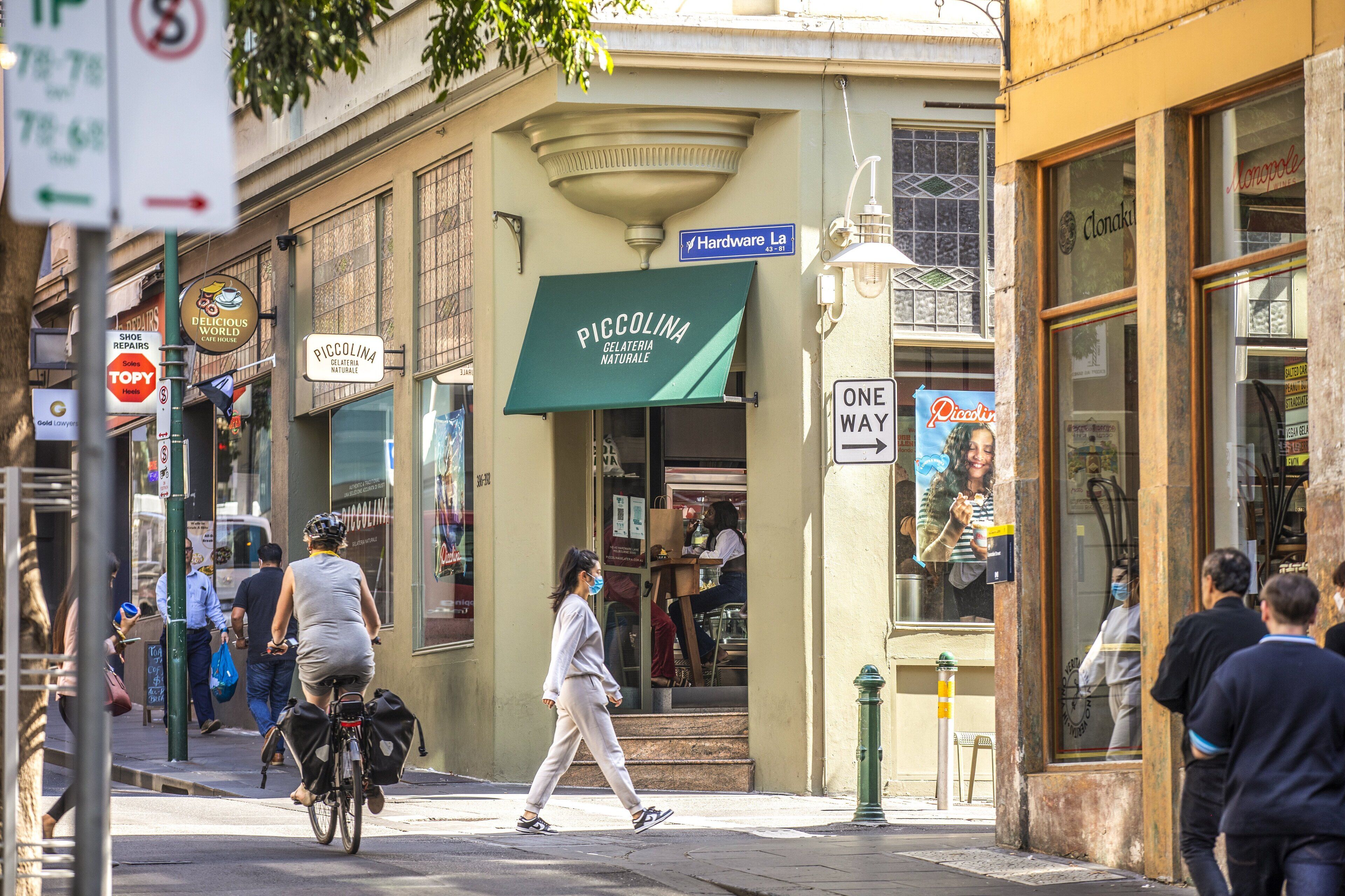 A street scene with a storefront named "Piccolina Gelateria Naturale" and a sign for "Hardware La".