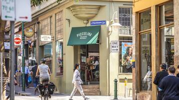 A street scene with a storefront named "Piccolina Gelateria Naturale" and a sign for "Hardware La".