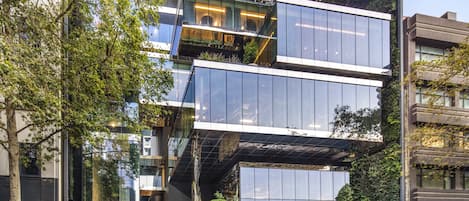 A modern building with a glass facade, a covered entrance, and the name "VOCO" visible on the entrance.