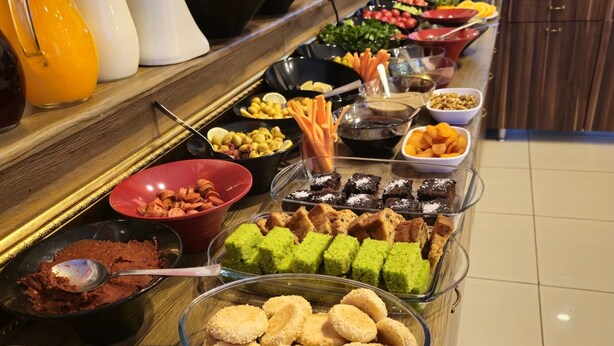 Un bufé con diversos alimentos, como frutas, verduras y postres.