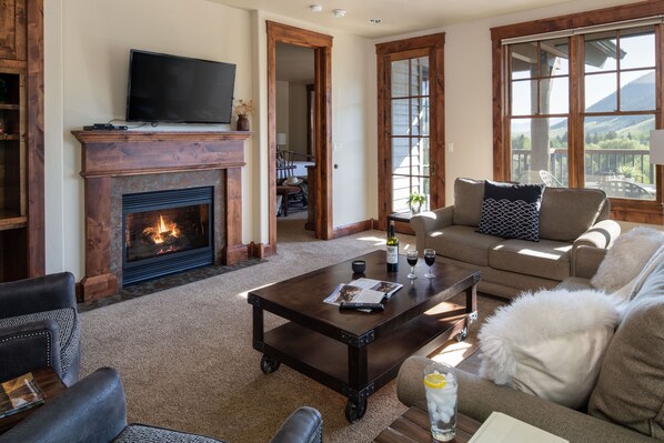 A cozy living room with a fireplace, a television, and a comfortable seating area. - Outpost: Grand View 2740 - AC and Private Patio! (Jackson)