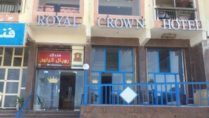 El exterior del Hotel Royal Crown con un cartel, la entrada y una escalera que conduce a ella.