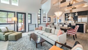 A spacious living area with a large sofa, a dining table, and a kitchen area with modern appliances. - 211 South Oak Street C | Luxury Telluride Townhome Steps to the Gondola (Telluride)