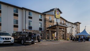A multi-story hotel with a stone facade, a My Place sign, and a tented outdoor area. - My Place Hotel - Marion, OH (Marion)
