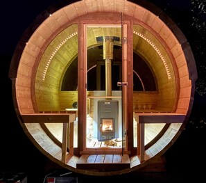 A circular wooden structure with a fireplace at the center, surrounded by a wooden railing. - Mas de l'Aranyó - Eco Wellness Spa (Aranyo, L')