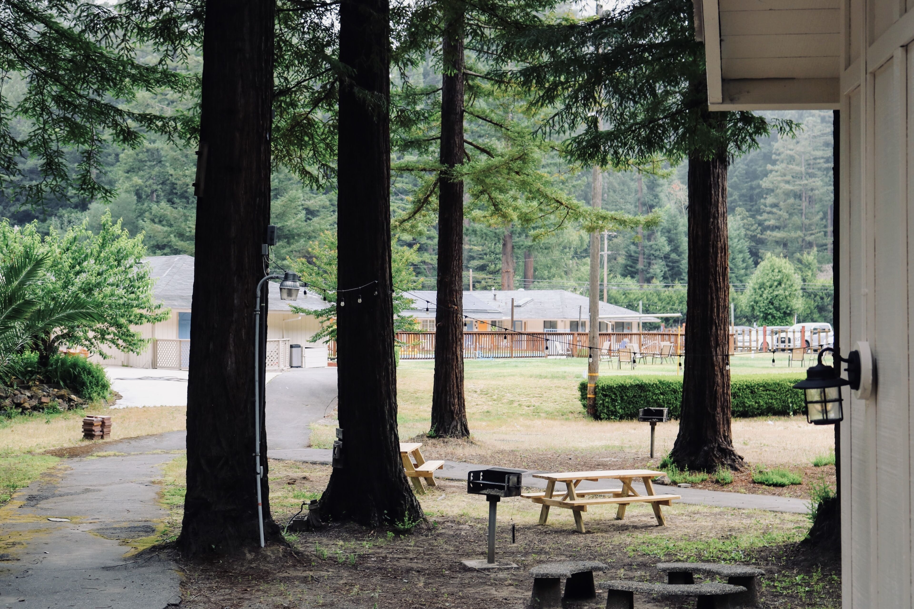 A covered outdoor area with picnic tables, benches, and a mailbox.