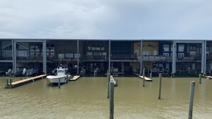 Un edificio sul lungomare con più livelli, barche ormeggiate e un canale navigabile.