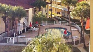 Ein Hotel mit Pool, Palmen und einem mehrstöckigen Gebäude.