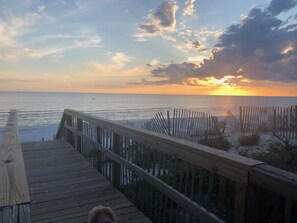 A wooden boardwalk leading to a beach with a sunset in the background. - 2 night minimum! Flexible Booking Dates! (Cape San Blas)