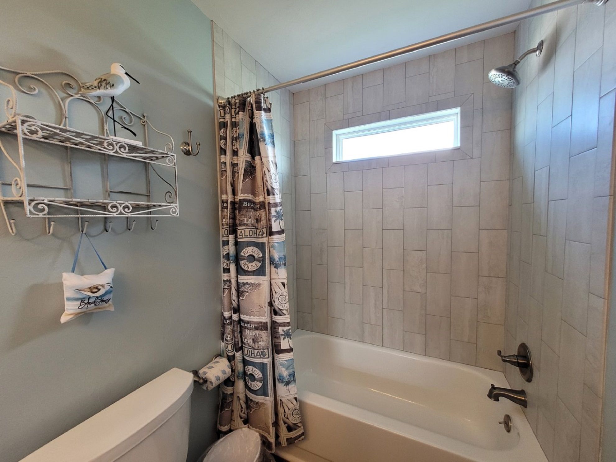 Ein Badezimmer mit Badewanne, Dusche und Handtuchhalter mit Handtuch und einem dekorativen Gegenstand.