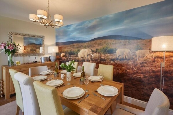 Enjoy dining in a spacious room with a large table, six chairs, and a stunning mural of a savannah landscape.