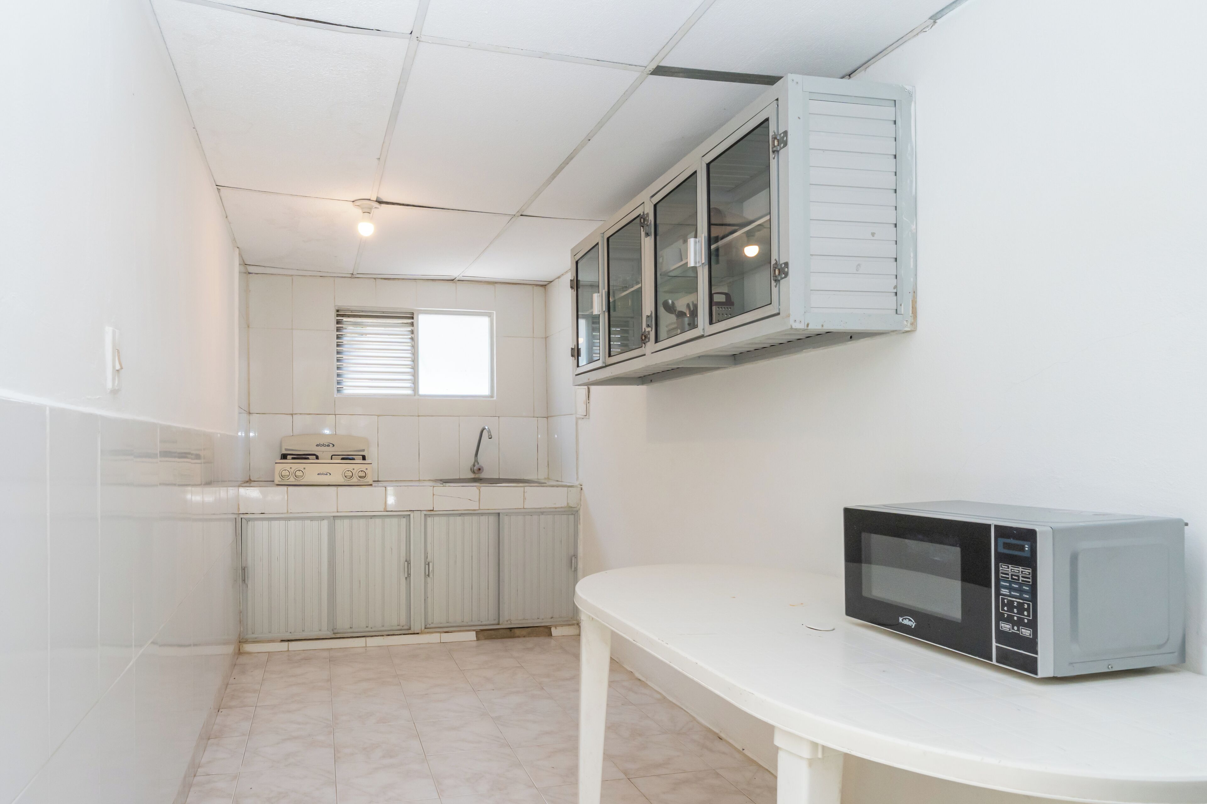 A kitchen with white cabinets, a microwave, and a sink.