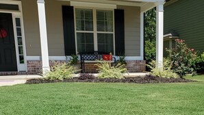 A house with a covered porch, a brick foundation, and a well-maintained lawn. - Augusta Golf Course Rental Home MASTERS (Evans)