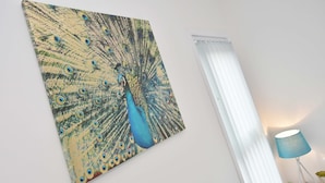 A wall with a peacock painting and a lamp on a white surface. - Townhouse @ 86 Brooklyn Street Crewe (Crewe)