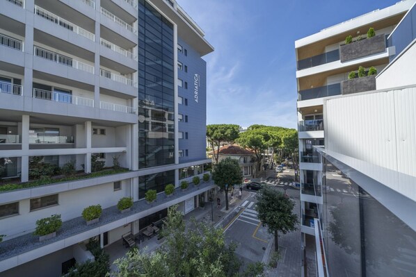 A multi-story building with balconies, a courtyard, and a street view.