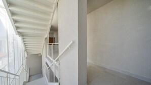 A staircase with white railings and a plain wall.