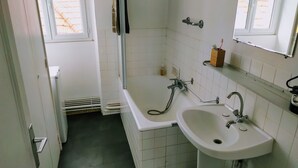 A bathroom with a bathtub, a sink, and a window. - Connected studio with open view - CENTRE-VILLE (Nantes)