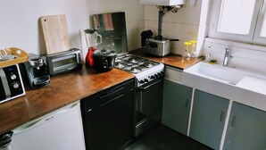 A compact kitchen with a toaster, blender, stove, and sink. - Connected studio with open view - CENTRE-VILLE (Nantes)