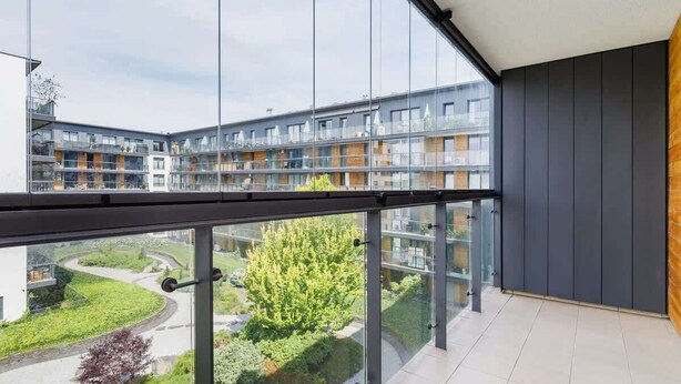 A modern apartment with large windows, a balcony, and a view of a residential area. - Stylish Apartment with a Balcony | Parking | Close to Kazimierz (Kraków)