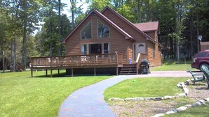 A wooden cabin with a deck and a pathway leading to it. - Lovely Mount Storm Waterfront Lake House - pet friendly, child friendly retreat (Mt Storm)