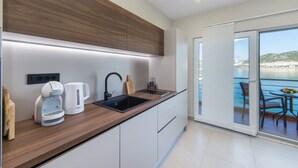 A modern kitchen with a wooden countertop, a sink, and a coffee maker. - Apartments Ema-Comfort Two Bedroom Apartment with Sea View (Rogotin)