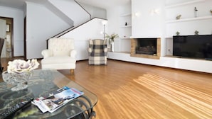 A modern living room with a glass coffee table, a fireplace, and a television. - Bernia Golf by Interhome (Altea)