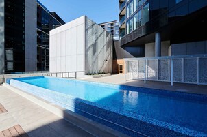 Un edificio moderno con piscina, ventanas amplias y fachada de hormigón.
