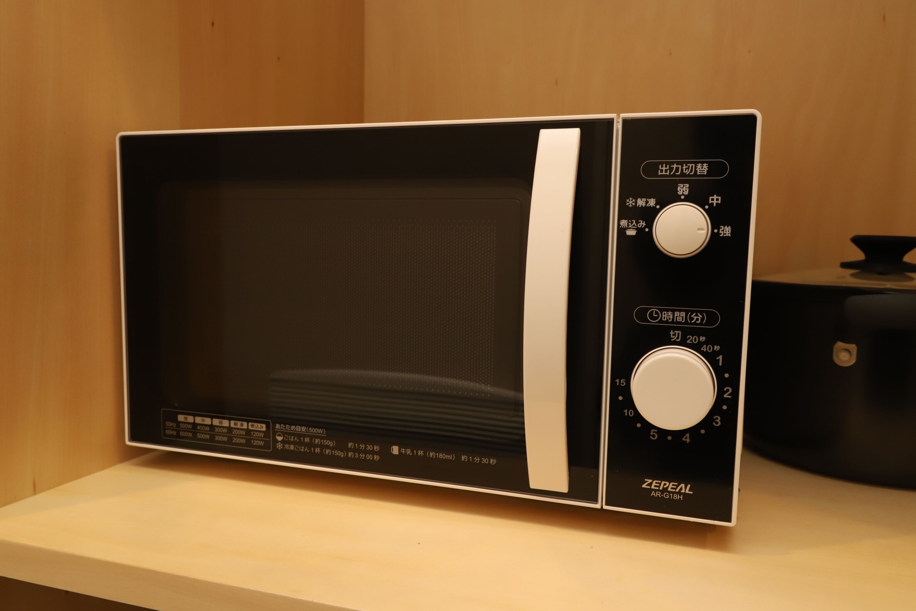 A microwave oven with a digital display, control knobs, and a power button.