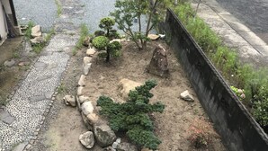 A garden with a pebble path, rocks, and small trees. - Guesthouse Sangenya (Shirahama)