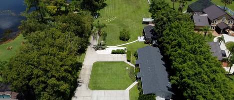 Eine Vogelperspektive eines Wohngebiets mit großem Rasen, einem Pavillon und einem Haus mit dunklem Dach.