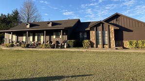 A two-story building with a covered porch and stone accents. - Located near the historic capitol of the Chickasaw Nation and Blue River (Tishomingo)