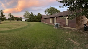 A grassy field with a building and trees. - Located near the historic capitol of the Chickasaw Nation and Blue River (Tishomingo)