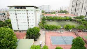 A high-rise building with multiple floors, a tennis court, and surrounding greenery. - Huong Duong Hotel (Hanoi)