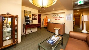 A hotel lobby with a reception desk, a large chandelier, a wooden cabinet, and a brown leather sofa. - The L.A. Mart Hotel Kyoto (Kyoto)