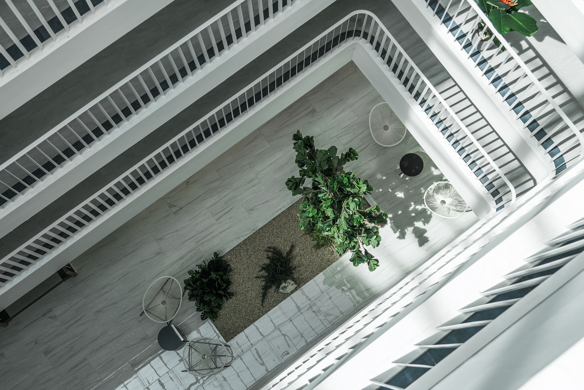 A multi-level atrium with a central garden area, multiple seating arrangements, and a modern architectural design.