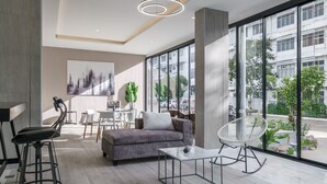 Un salon moderne avec un canapé, une table à manger et une grande fenêtre donnant sur la ville.