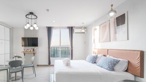 Une chambre d’hôtel moderne équipée d’un grand lit, d’un bureau, d’une chaise et d’une télévision.