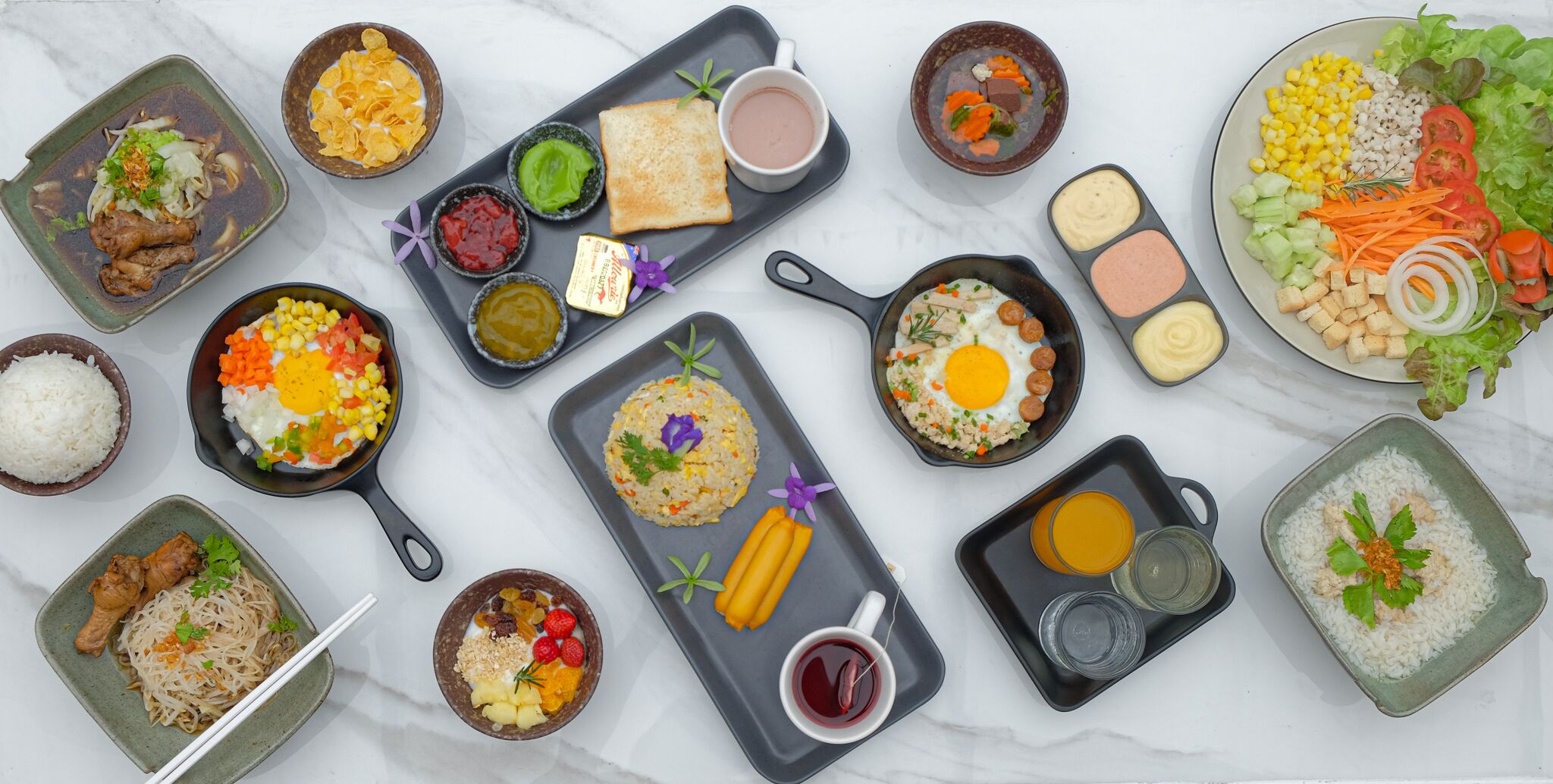 Variedad de platos que incluyen arroz, fideos y un plato con verduras y maíz.