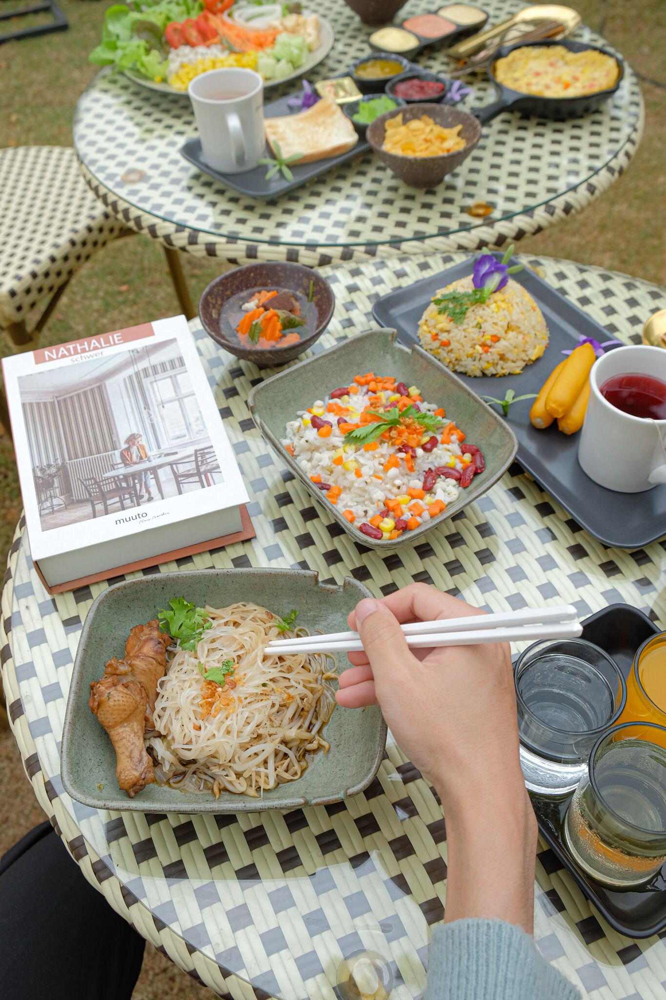 A table with various dishes, including rice, vegetables, and meat, and a book titled 'Nathalie'.