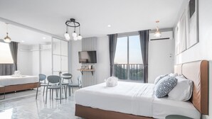 Une chambre d’hôtel moderne, dotée d’un grand lit, d’un bureau et d’une télévision.