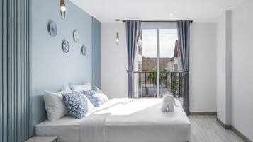 A modern bedroom with a large bed, a view of the outside, and a balcony.