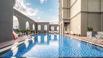 Alberca al aire libre, sombrillas en la alberca y camastros