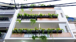 A modern building with multiple balconies, large windows, and potted plants. - Cozrum Homes Saphera Residence (Ho Chi Minh City)
