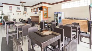 A hotel lobby with wicker furniture, a reception desk, and a refrigerator. - Jy Crown Palace (Cebu City)