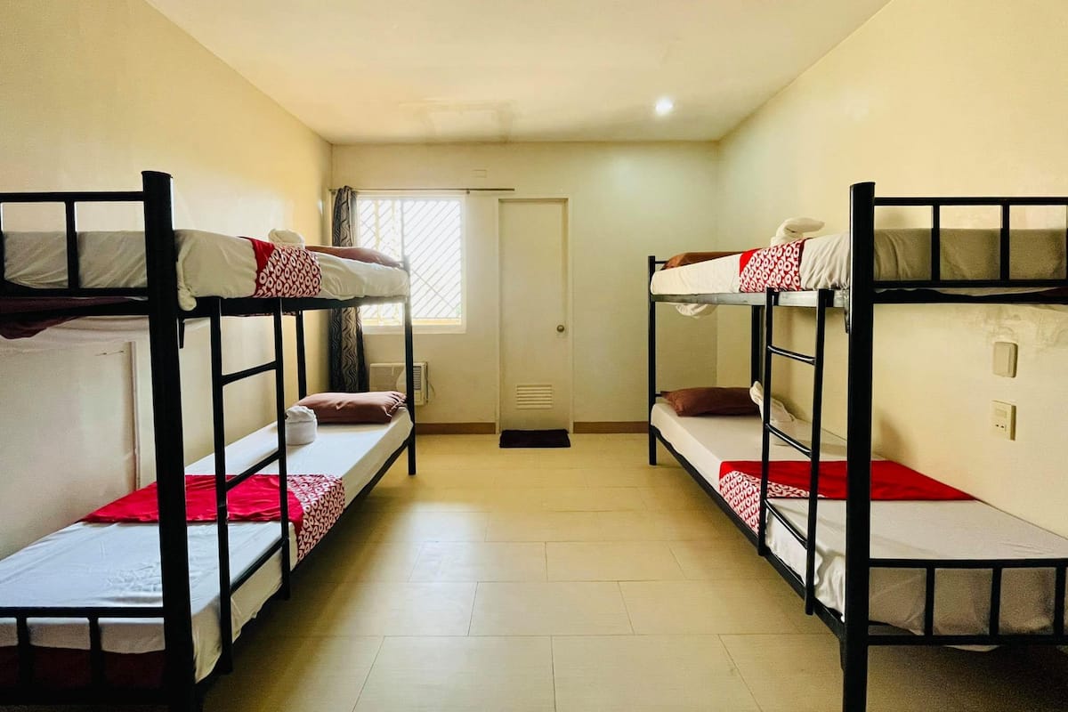 Un dormitorio con literas, una ventana con cortinas y una puerta.