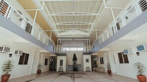 A spacious indoor area with a high ceiling, multiple levels, and potted plants. - Ljenj Apartelle (Mabalacat City)